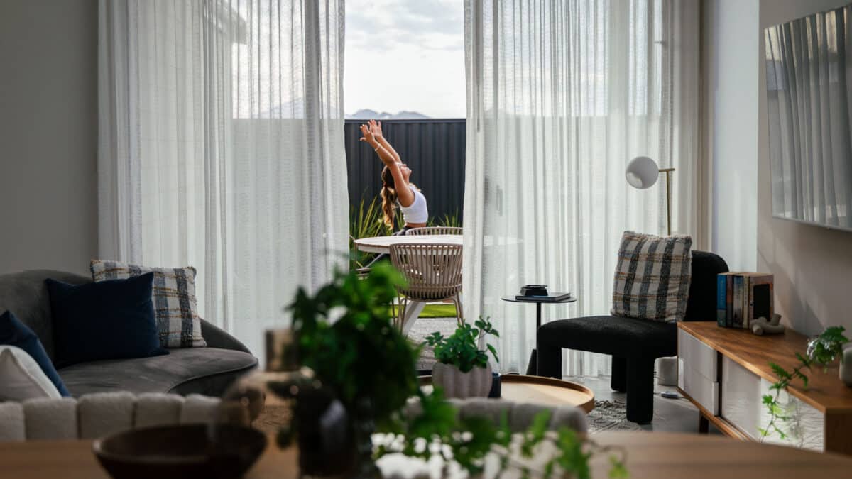 First home buyer created a space for wellness in her new first home, suited to her lifestyle. The view from the dining and living room shows her standing in